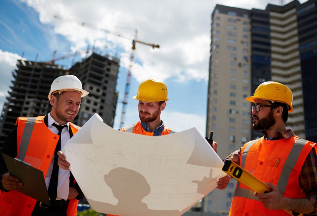 Team of inspectors looking at sketch on paper on construction-site